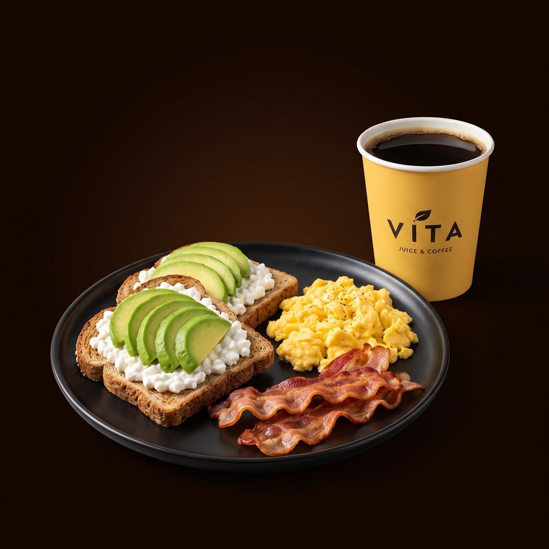 Tostadas con aguacate y queso cottage, huevos revueltos, bacón y un café en vaso de Vita